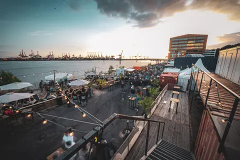 Gæster på Platz am Fischereihafen mellem containere og Elben