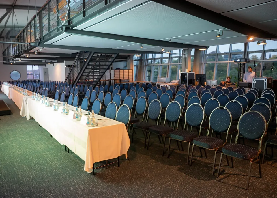 Lyst konferencelokale med stolerækker og stor glasfacade i Hafenlocation Hamburg